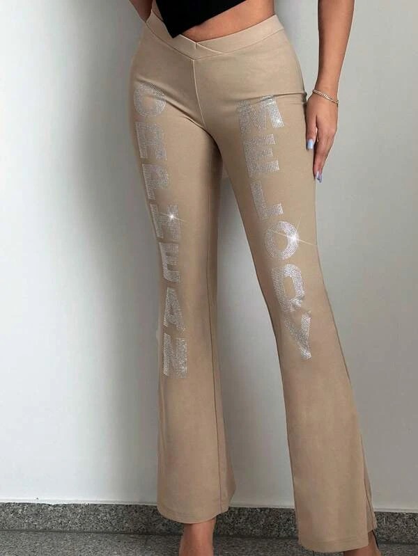 Pantaloni svasati con strass a forma di lettera.